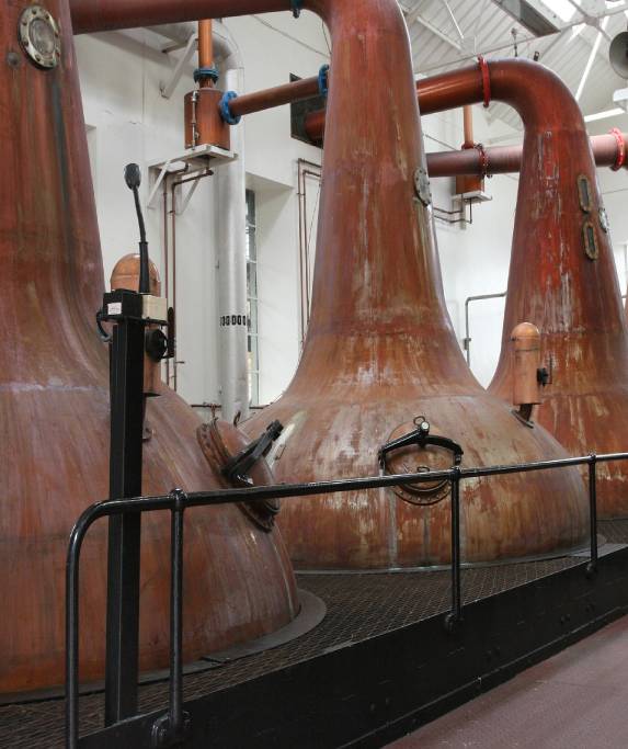 A group of large copper pots in a room.